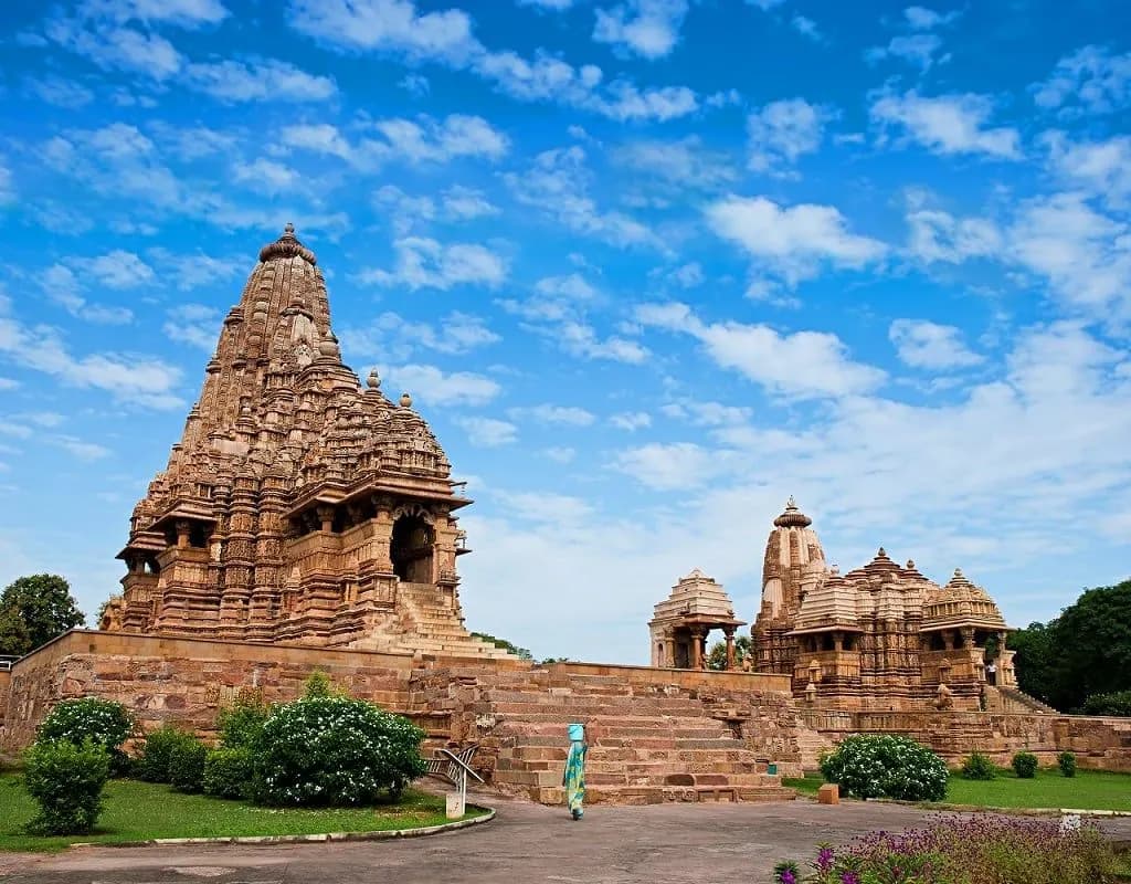 Carved sandstone temples at Khajuraho against a blue sky