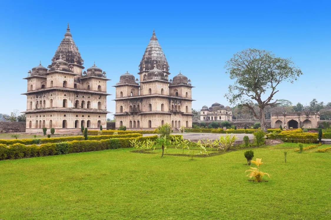 The royal cenotaphs of Orchha above green lawns