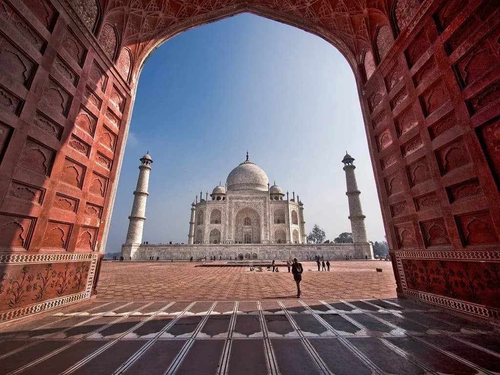 The Taj Mahal framed by a carved red sandstone archway
