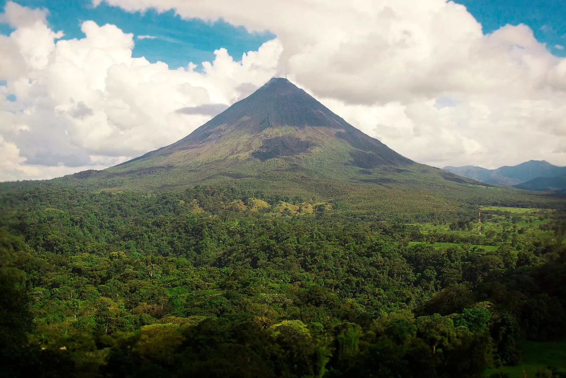 The cone of the Arenal Volcano above a broad sweep of rainforest