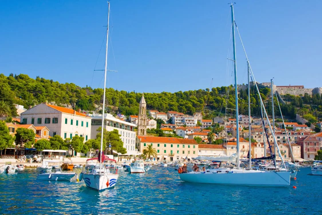 Sailing yachts moored in Hvar harbour below the old town
