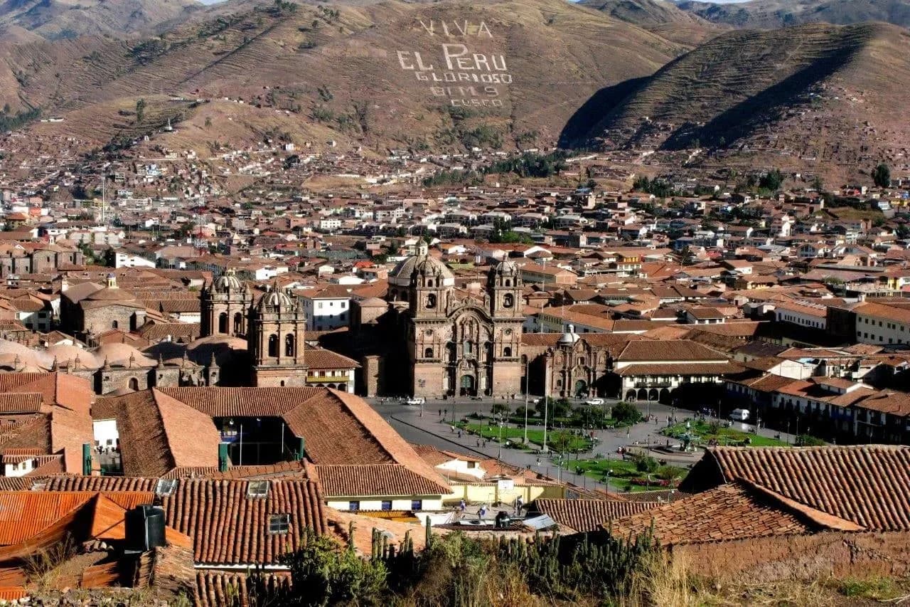 Terracotta rooftops of Cusco around the main square with hills behind