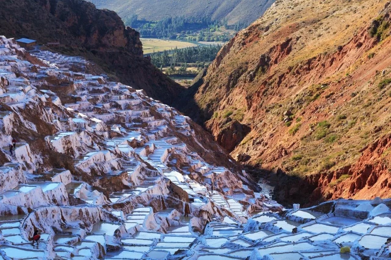 The white salt pans of Maras stepping down a red-earth valley