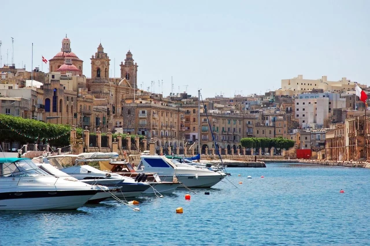 Boats in the marina below the old stone buildings of Vittoriosa