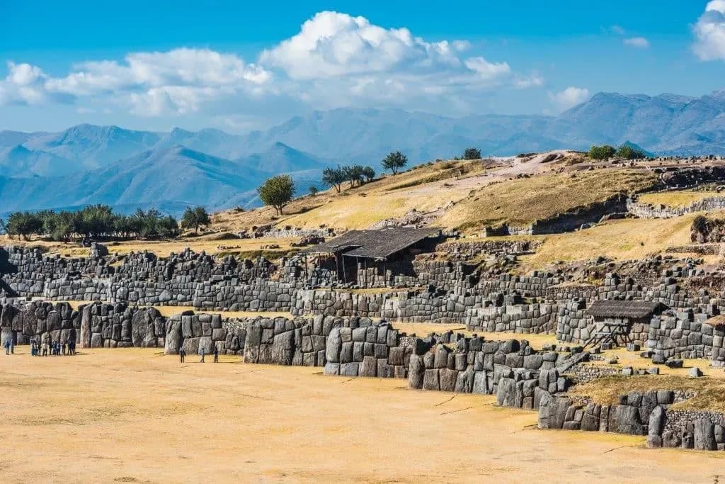 The zigzag stone walls of Sacsayhuaman with mountains on the horizon