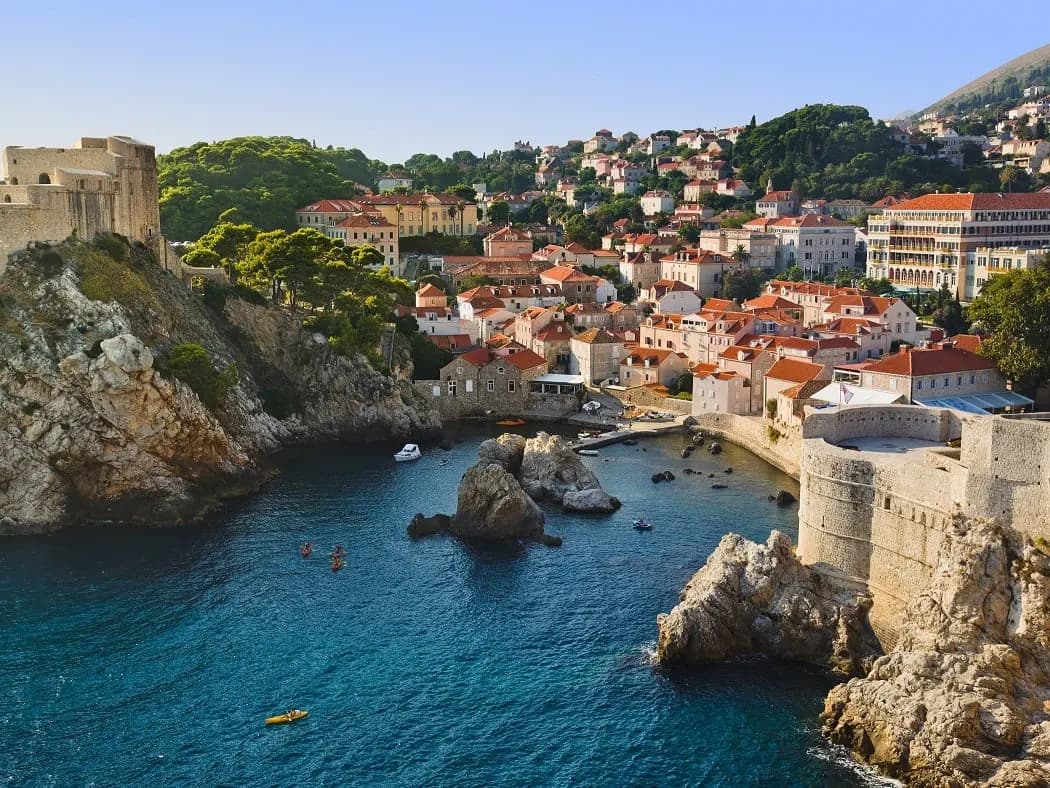 A rocky cove below the walls, with Lovrijenac fortress on the headland