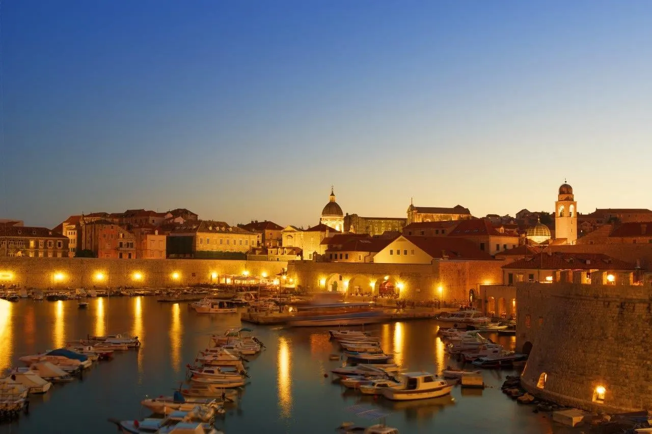 Dubrovnik's old port and walls lit up in the evening
