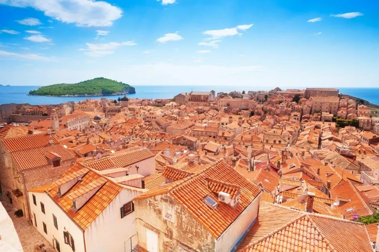 Terracotta rooftops of Dubrovnik's old town with Lokrum island beyond