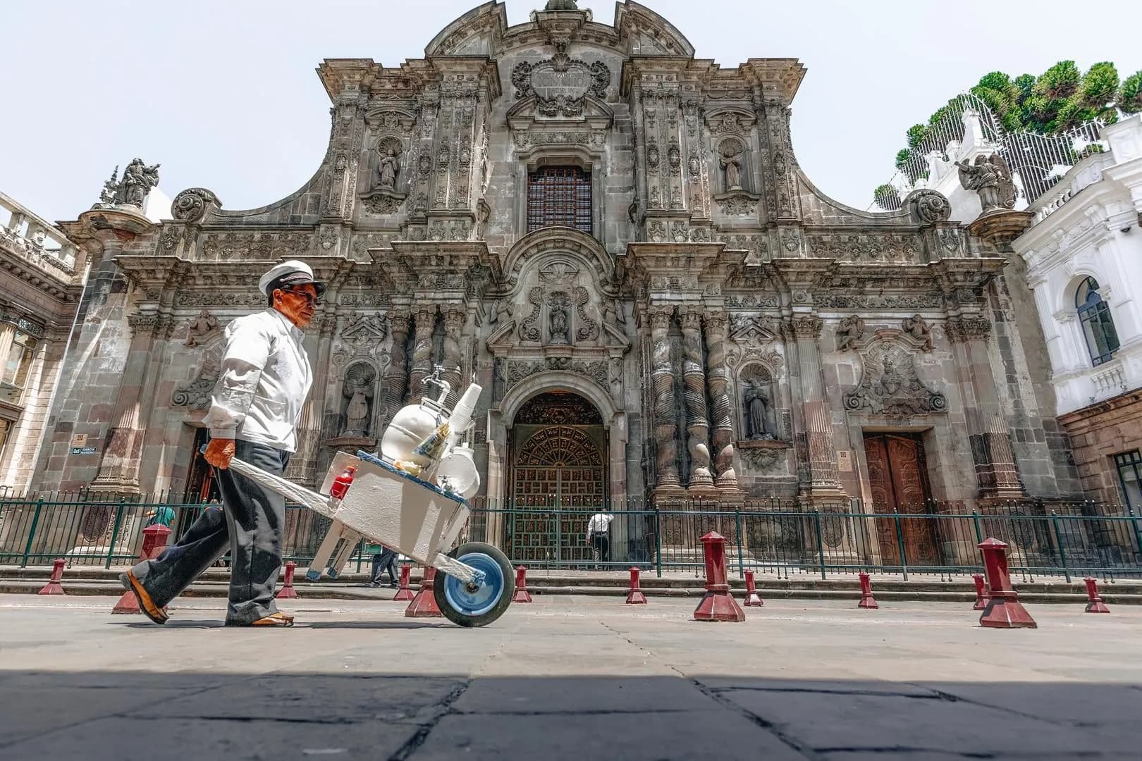 A street vendor passing the carved stone front of a baroque church