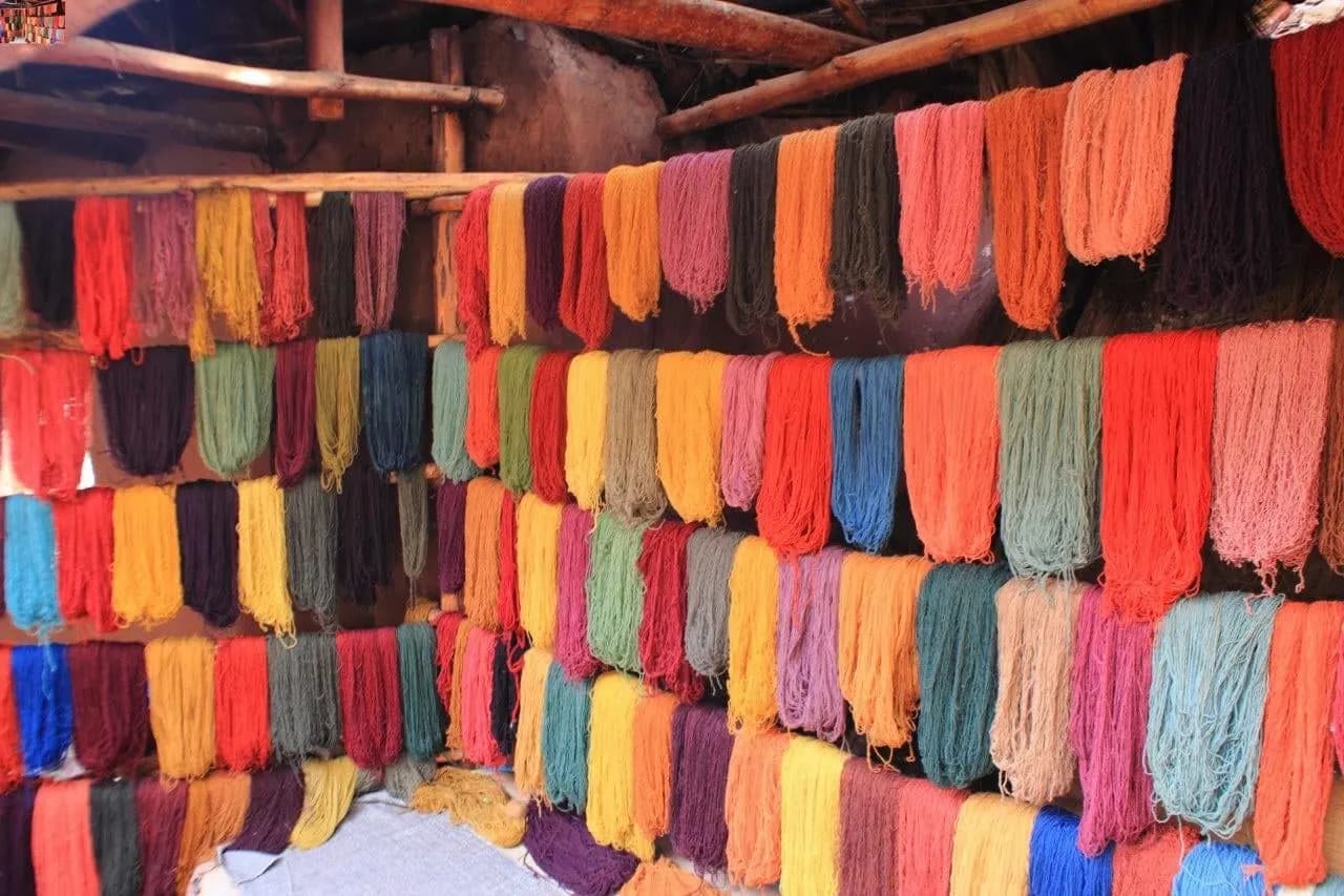 Hanks of naturally dyed wool hanging in rows at an Andean weaving centre