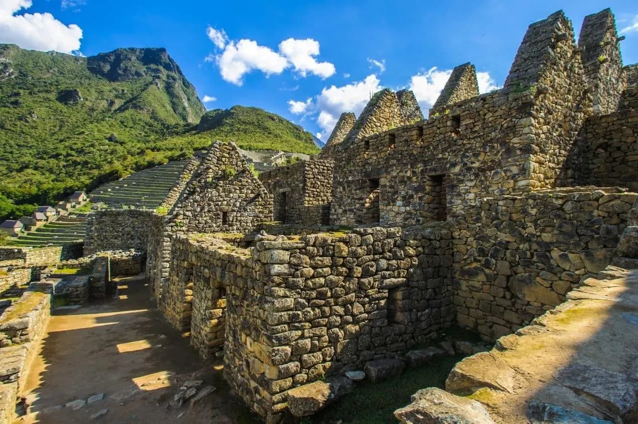 Inca stone walls and gables at Machu Picchu under a blue sky