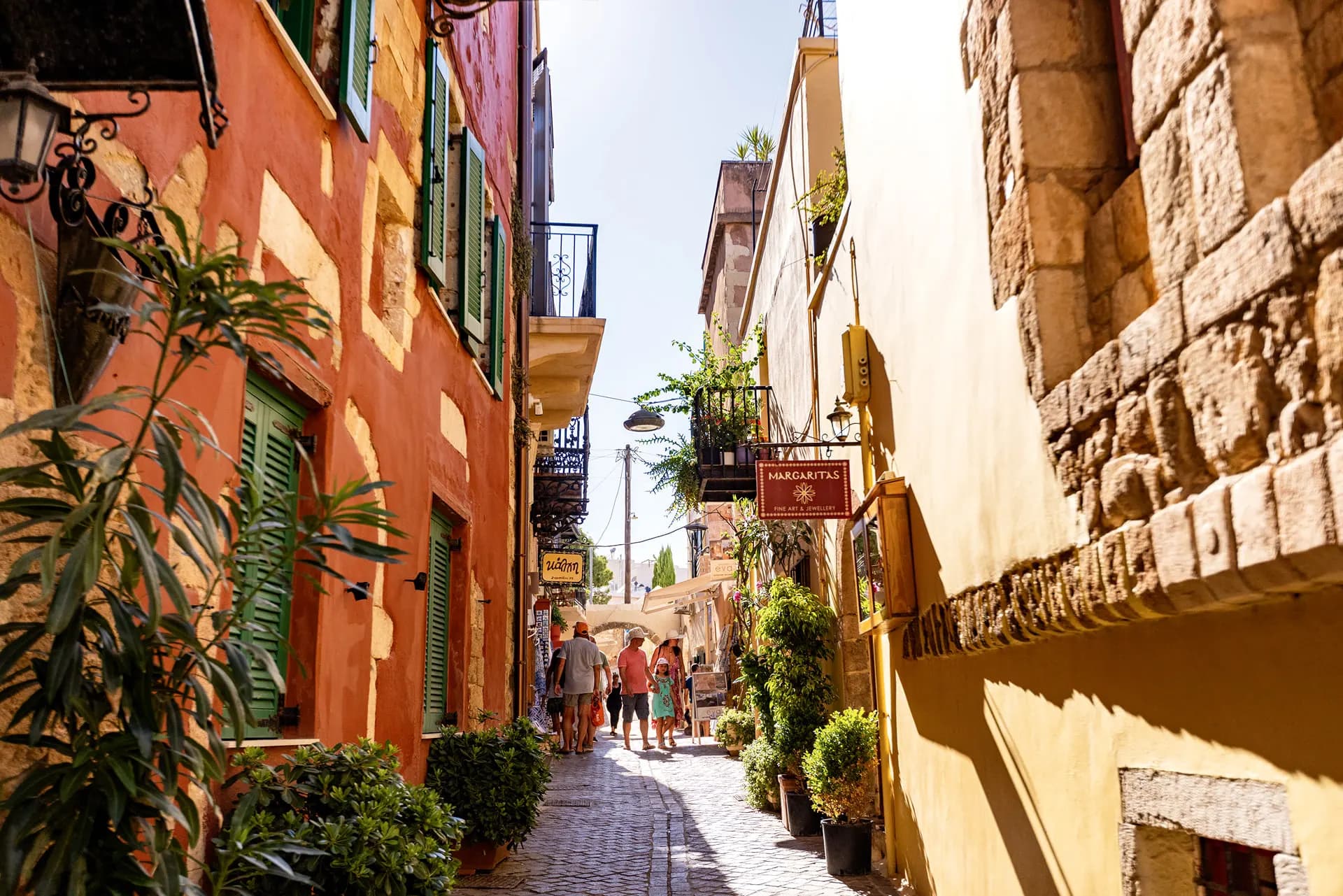 A narrow lane of ochre and orange houses in an old Cretan town