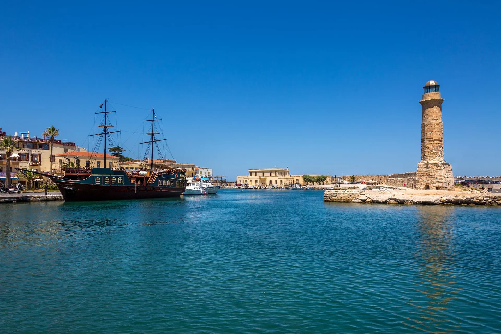 The old stone lighthouse and wooden ships in Rethymnon harbour