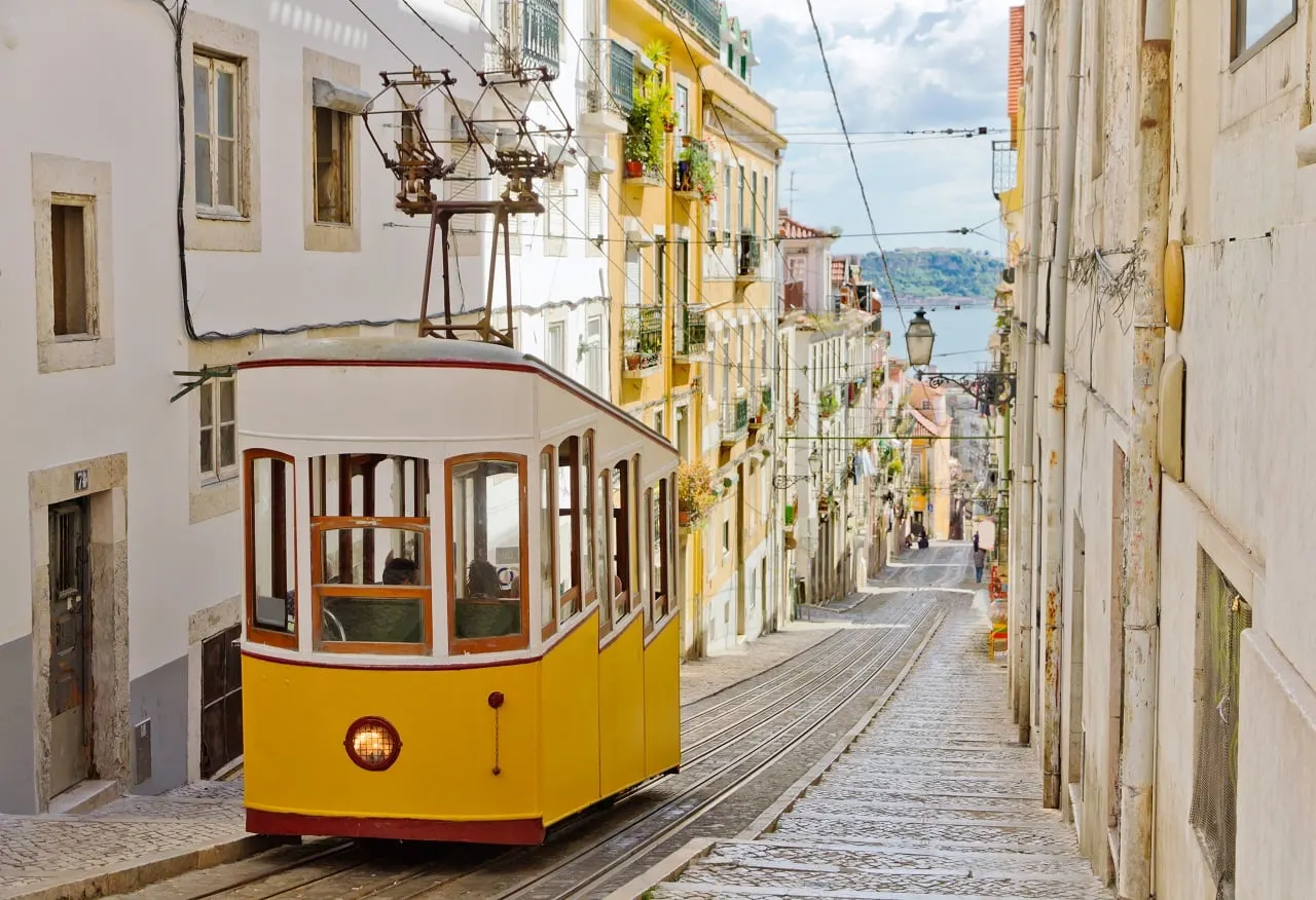 A yellow funicular tram climbing a steep street in Lisbon