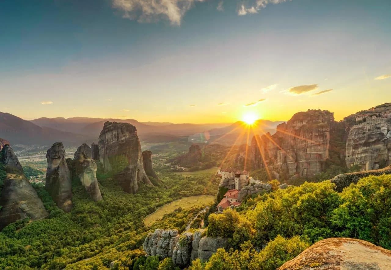The sun setting between the rock towers of Meteora