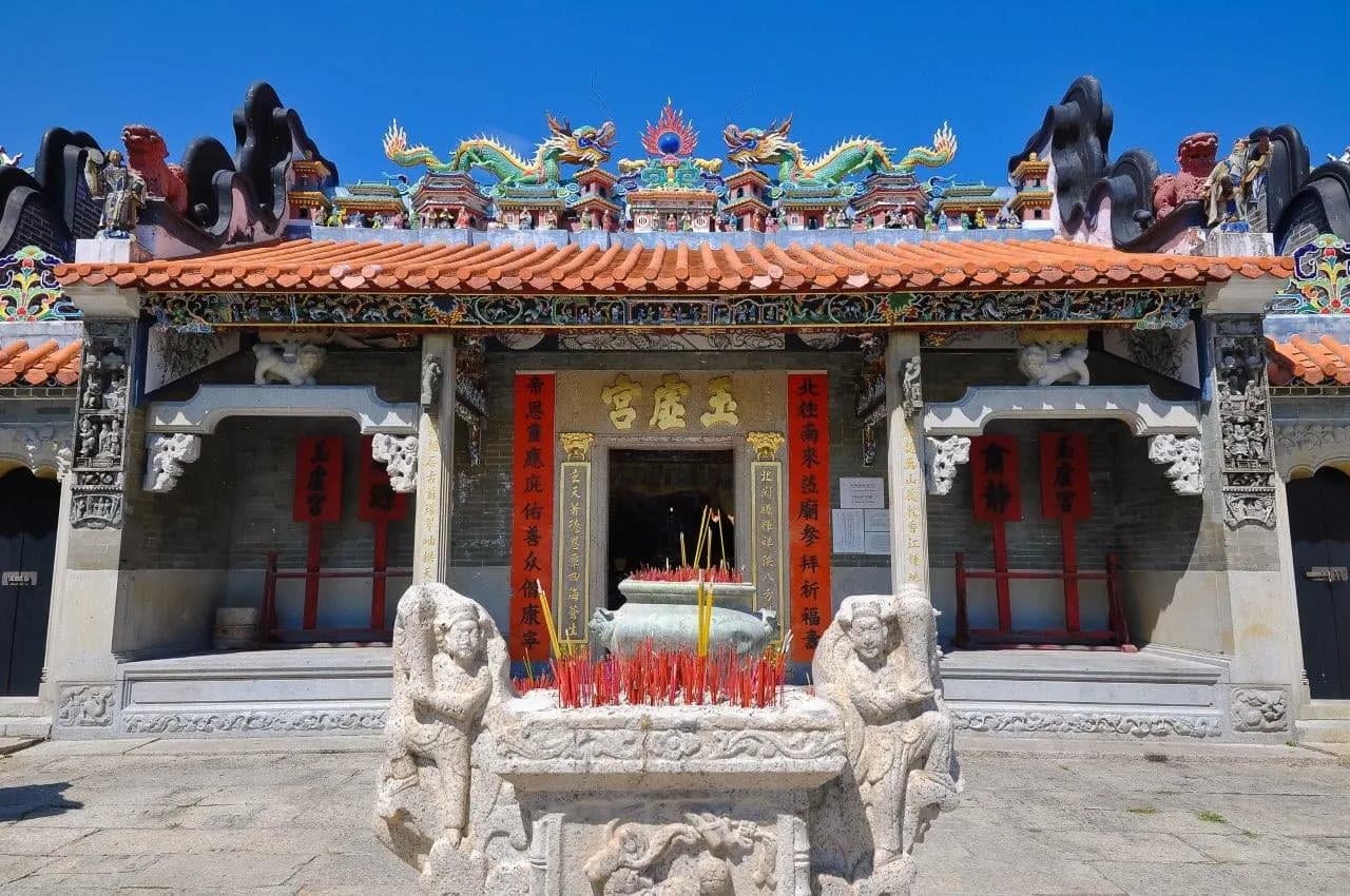 A carved ancestral hall with dragon figures along its roof ridge