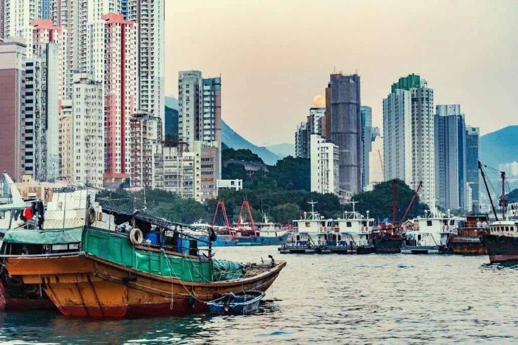 A wooden fishing boat in front of high-rise towers in Hong Kong