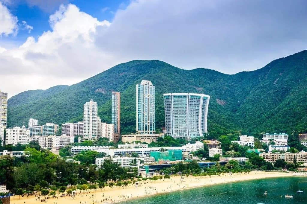 The beach at Repulse Bay below green hills and tall apartment towers