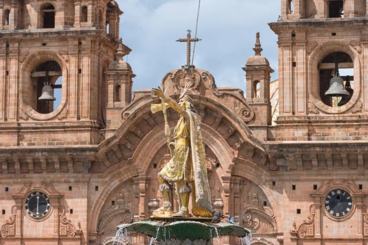 The Inca fountain on Cusco's Plaza de Armas in front of a carved stone church