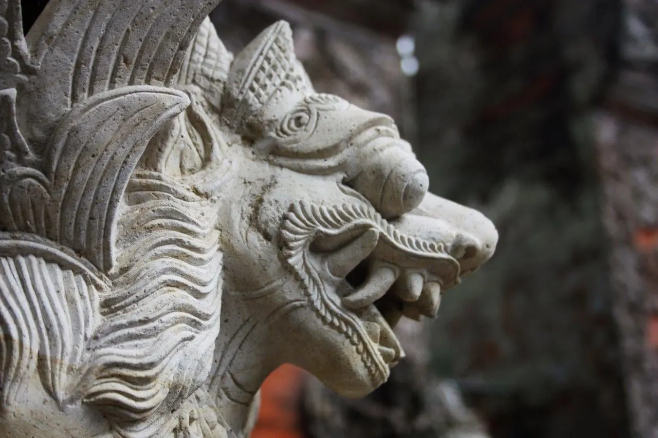 A carved stone guardian head at a temple entrance