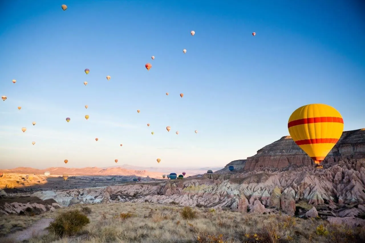 Hot air balloons drifting over the rock valleys of Cappadocia at sunrise