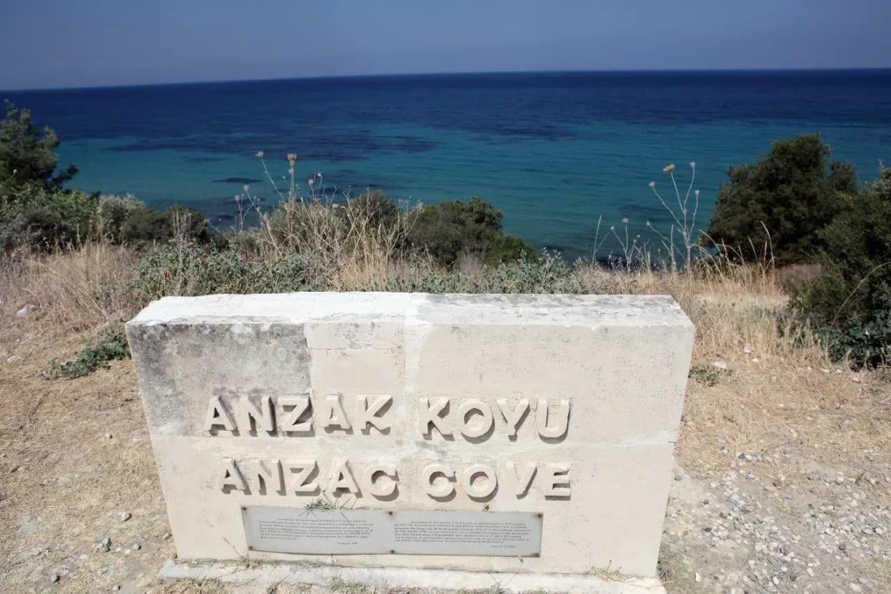 A stone marker reading Anzac Cove above the blue sea