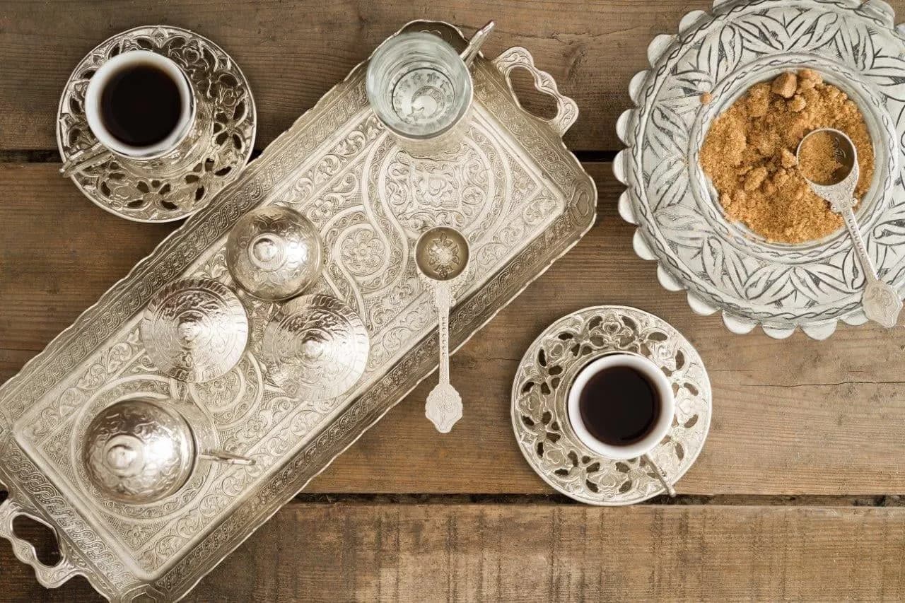 Turkish coffee served in small cups on an engraved silver tray