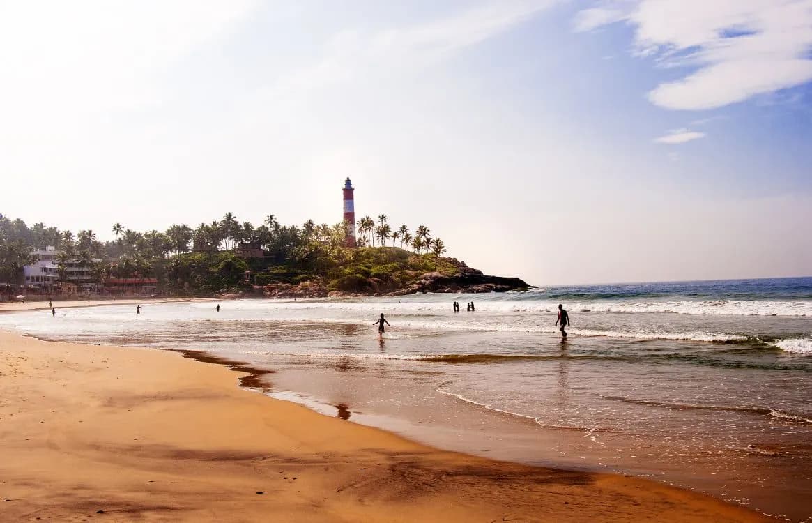 Lighthouse Beach at Kovalam, with the lighthouse on a palm-covered headland