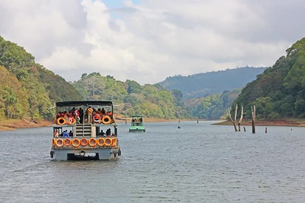 Boats on Periyar Lake between forested hills