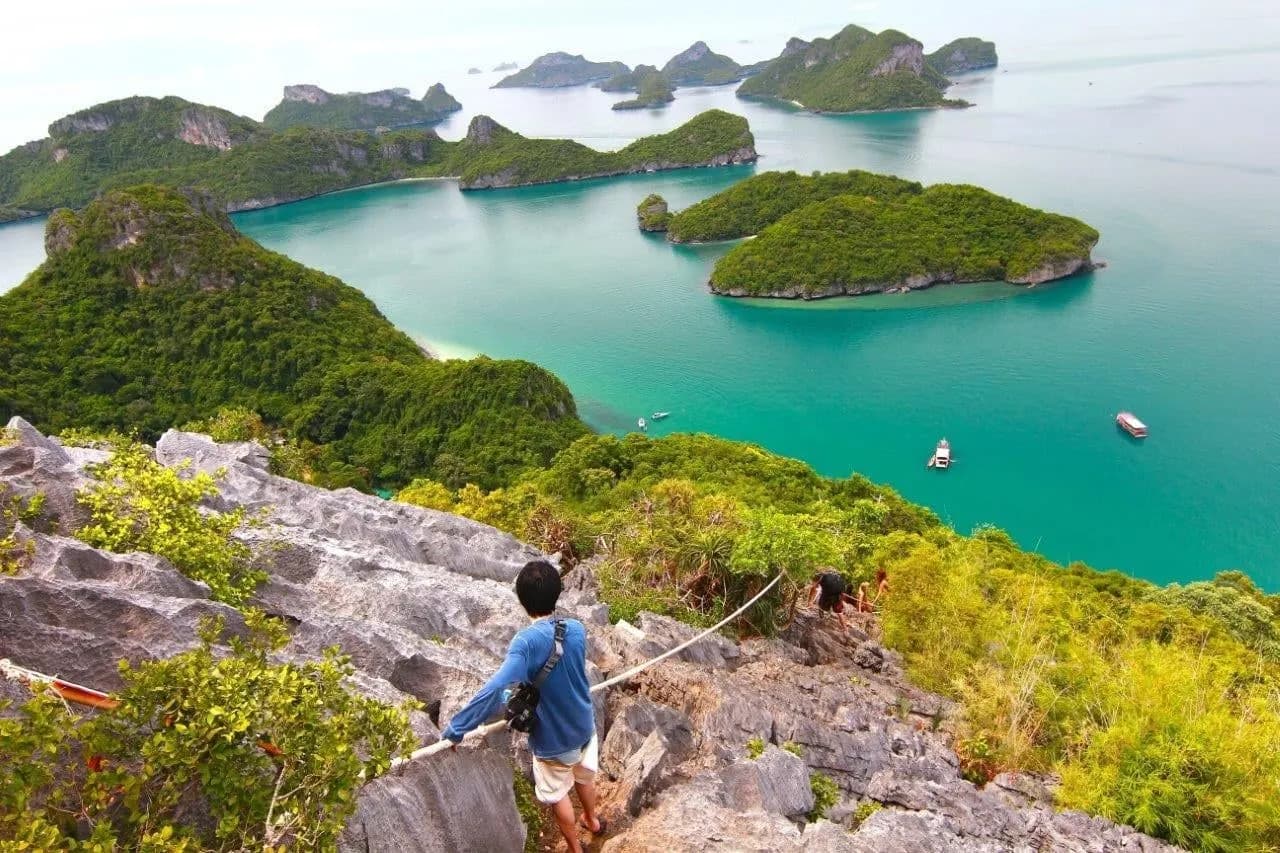 A walker on a limestone ridge above the green islands of Ang Thong Marine Park