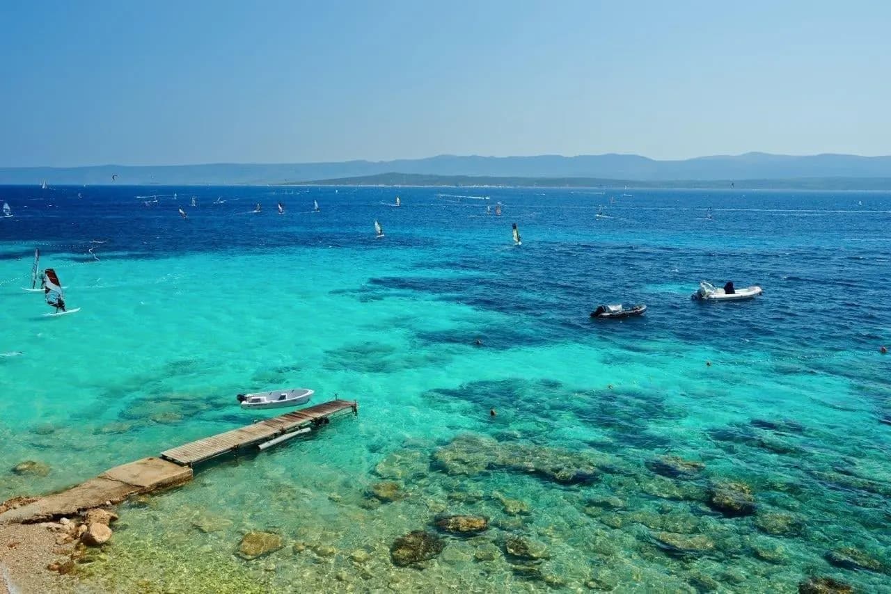 Clear turquoise shallows and a stone jetty on an Adriatic island