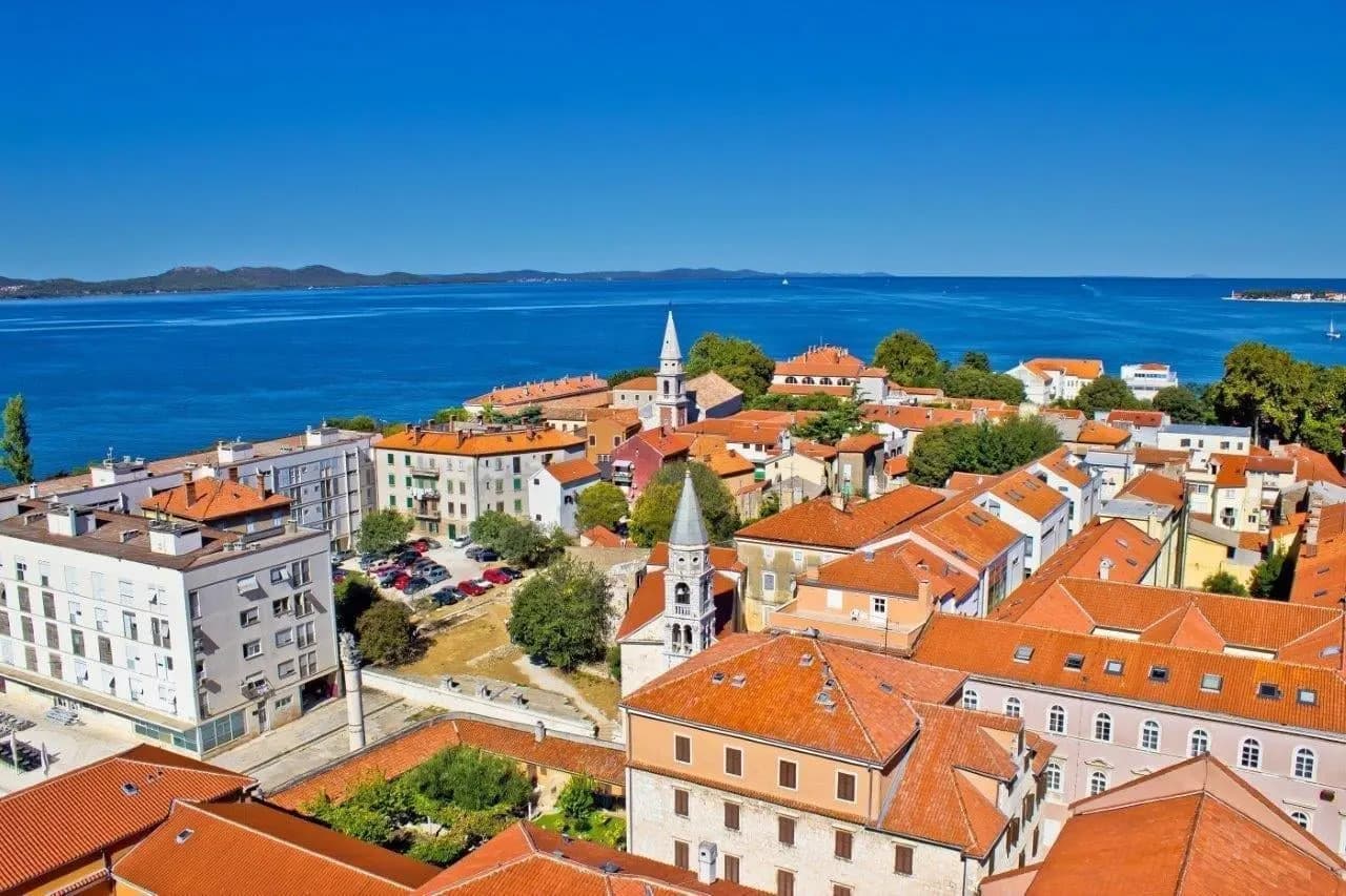 Zadar's red rooftops and bell tower beside the sea