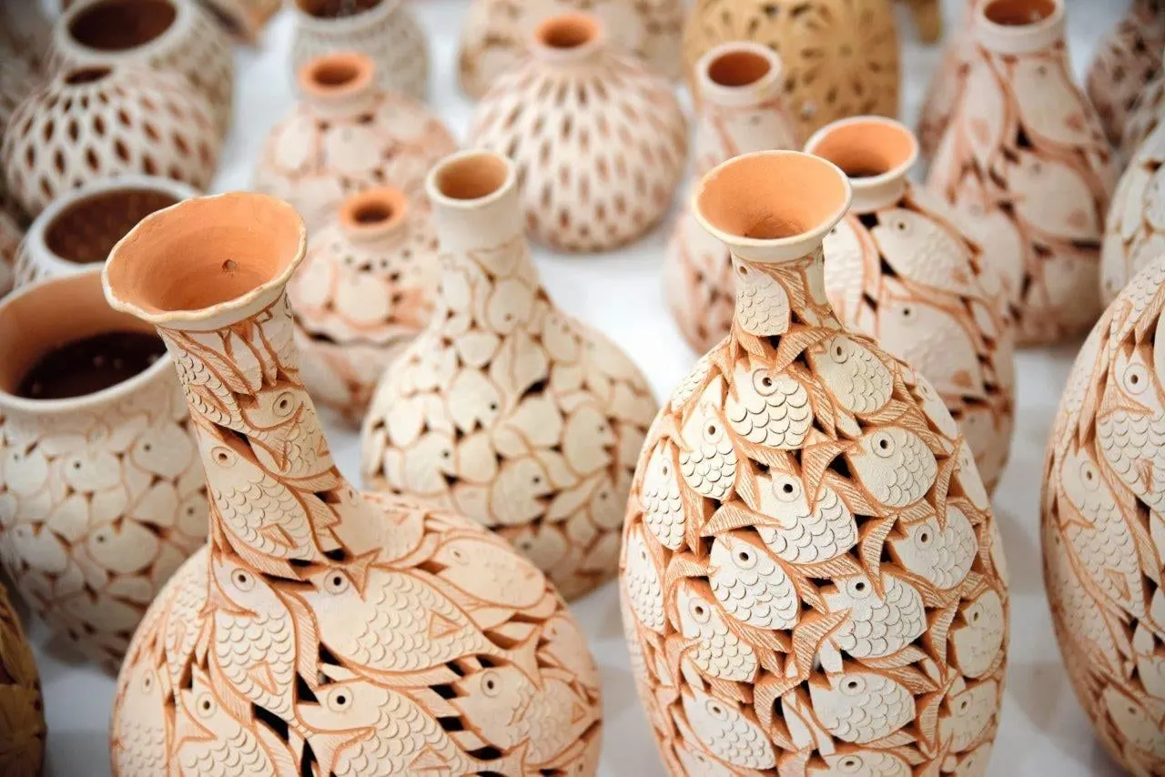 Hand-carved clay vases decorated with fish