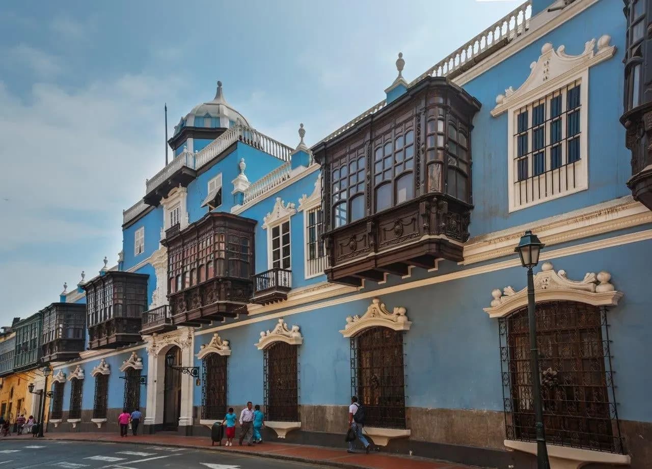 A blue colonial mansion with carved wooden balconies in Lima