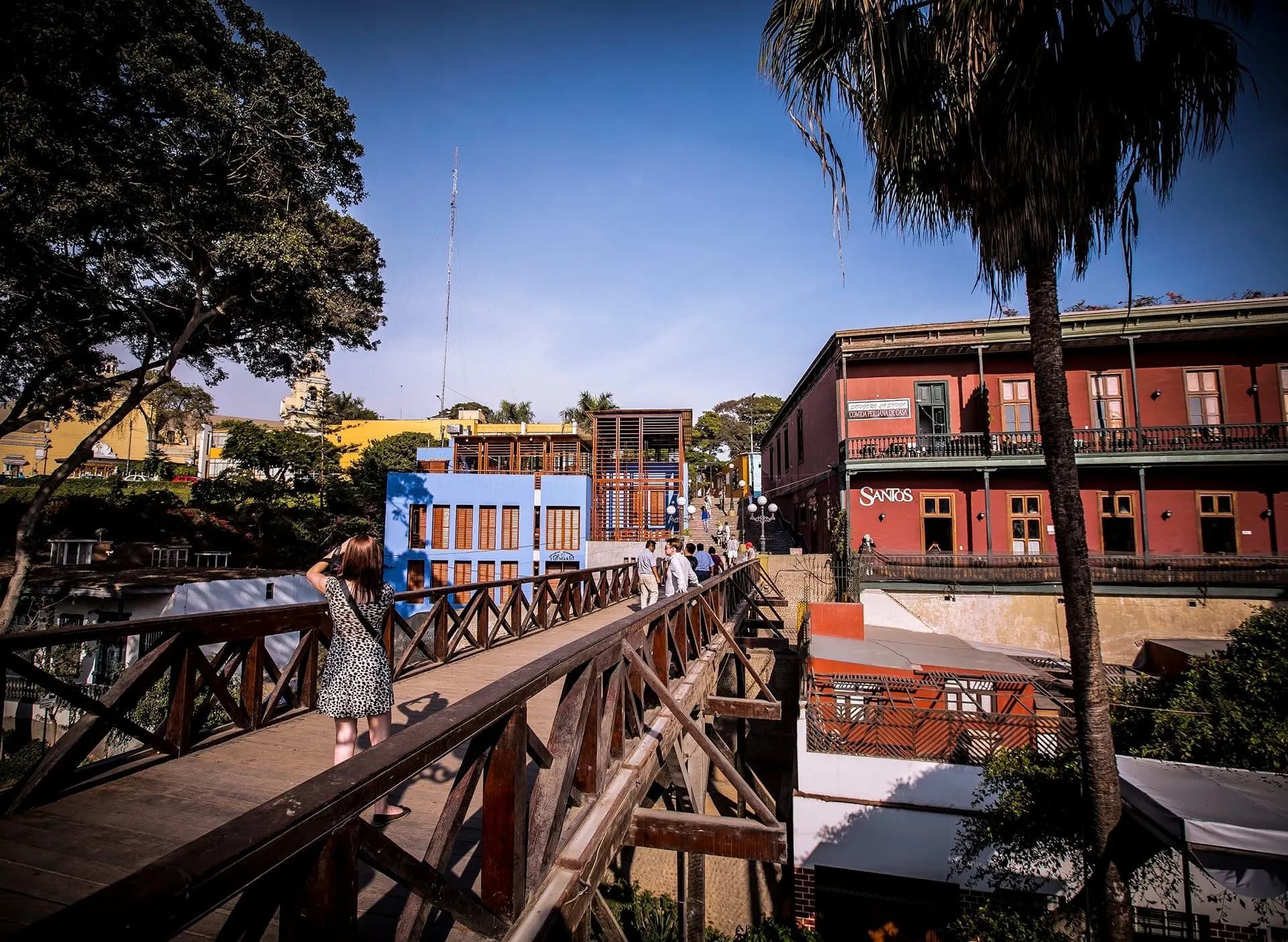 A wooden footbridge leading towards colourful old houses in Barranco