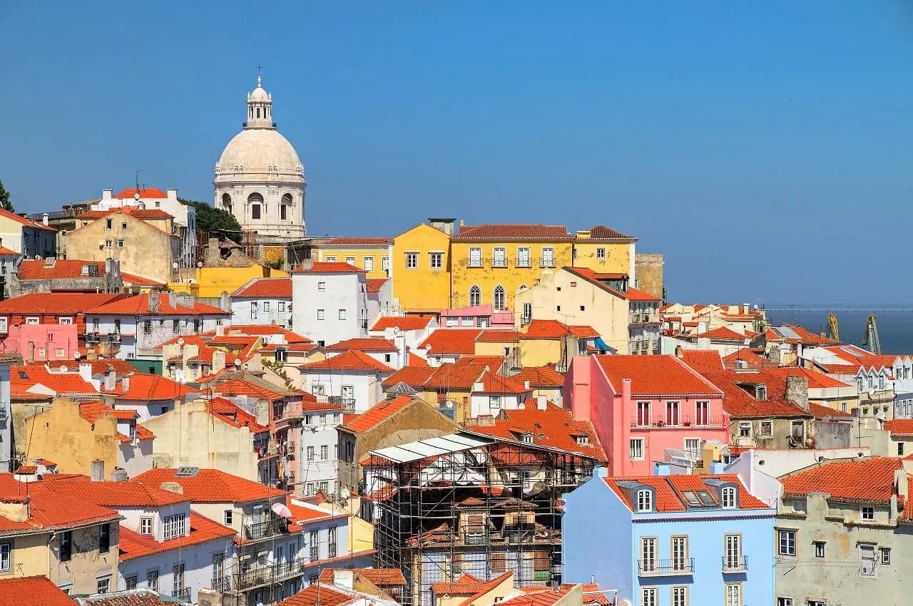 Coloured houses and terracotta roofs of Lisbon below a white dome