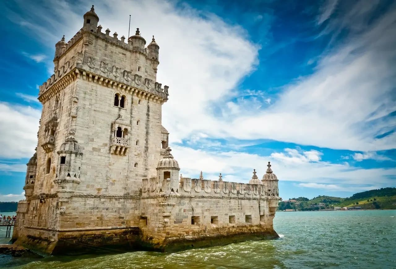 The Belém Tower on the edge of the Tagus River under a blue sky