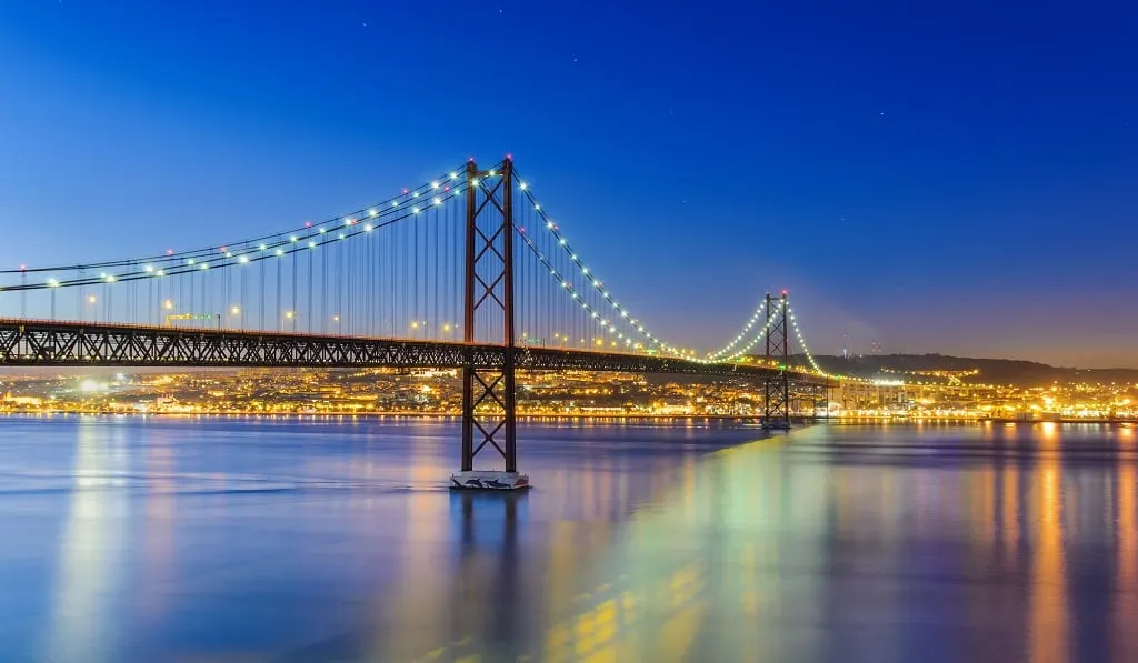 The long suspension bridge over the Tagus lit up at night