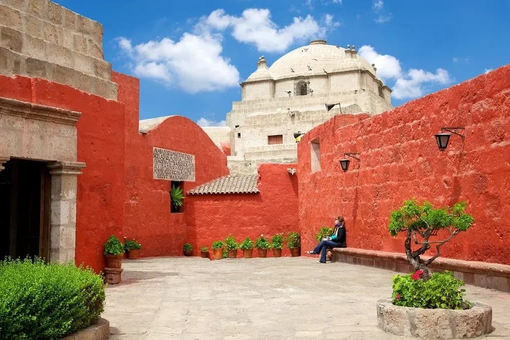 A red-walled courtyard and white dome inside the Santa Catalina Monastery, Arequipa
