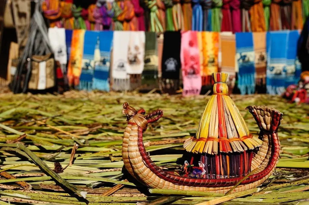 A small reed boat and woven textiles on a reed island of Lake Titicaca