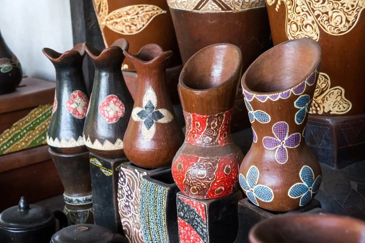 Hand-painted clay jugs and vases lined up in a pottery workshop
