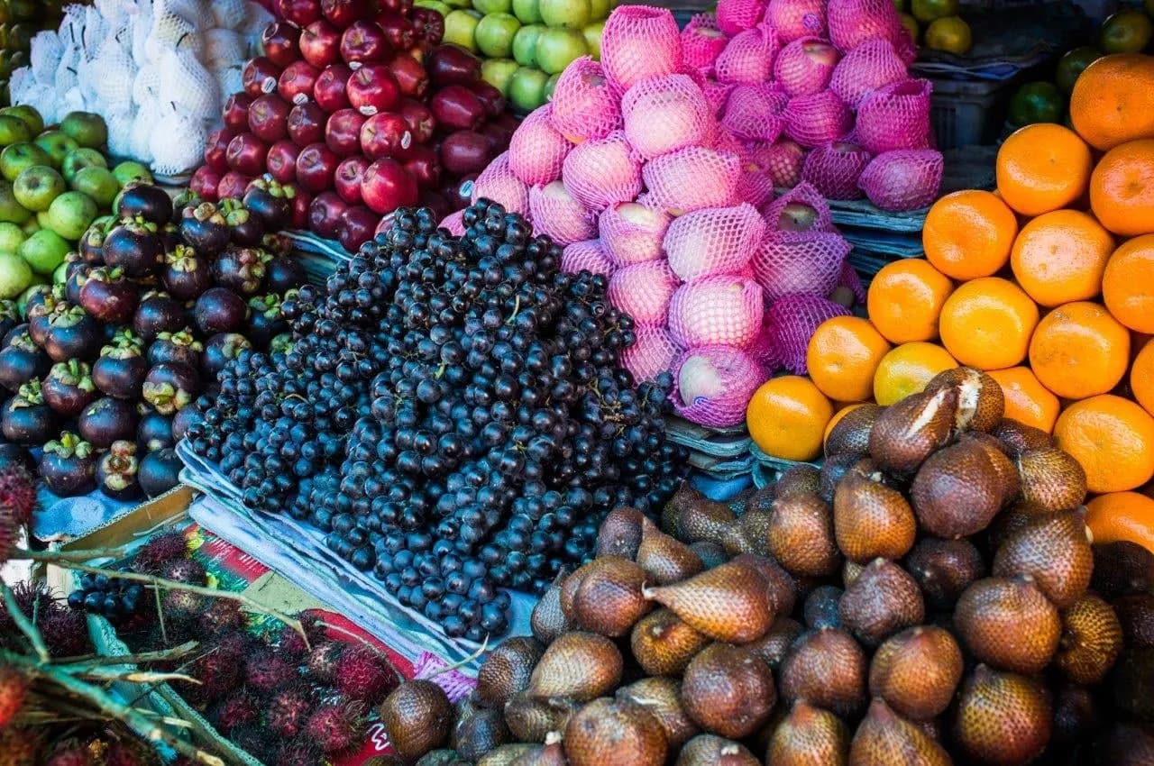 Snakefruit, mangosteen, oranges and other tropical fruit piled at a market stall