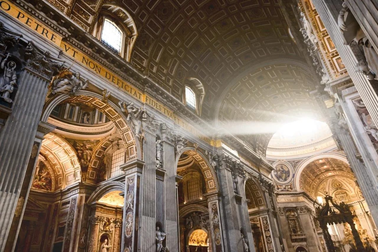 Sunlight falling across the gilded vaults inside St Peter's Basilica