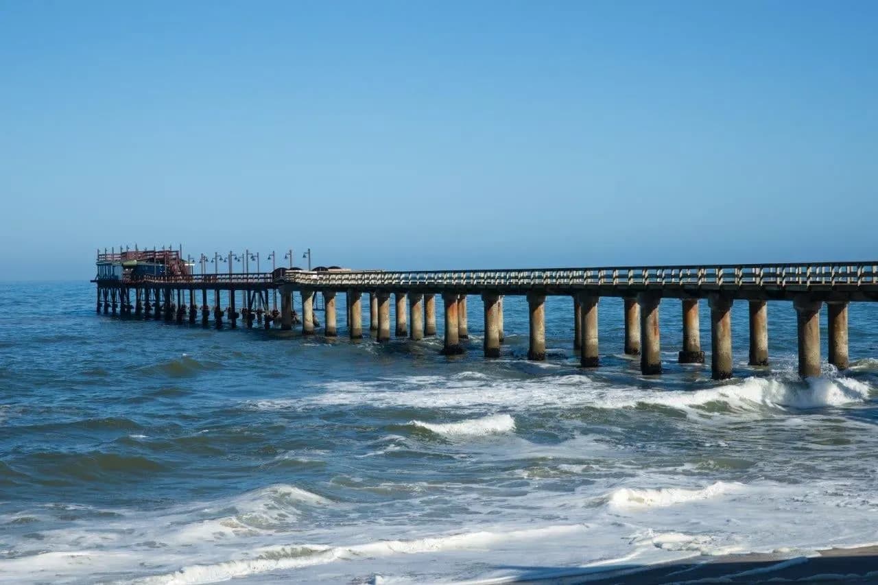 A long jetty reaching out over the Atlantic surf at Swakopmund