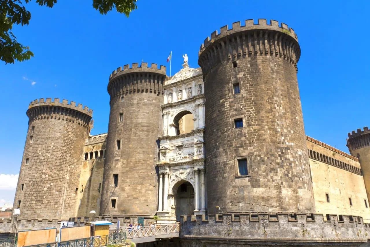 The round stone towers and white marble gateway of Castel Nuovo in Naples