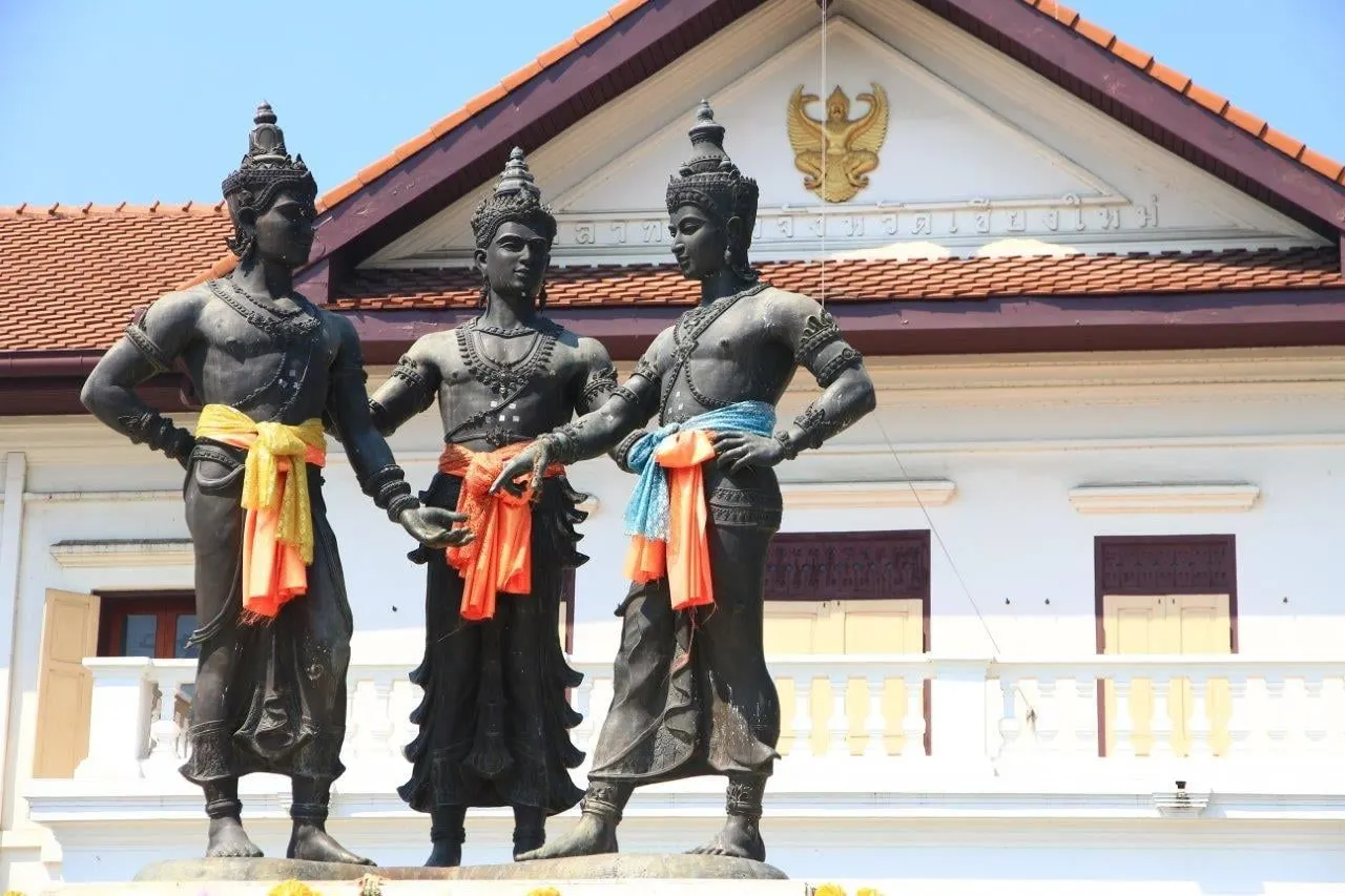 The Three Kings Monument in front of a white colonial building in Chiang Mai