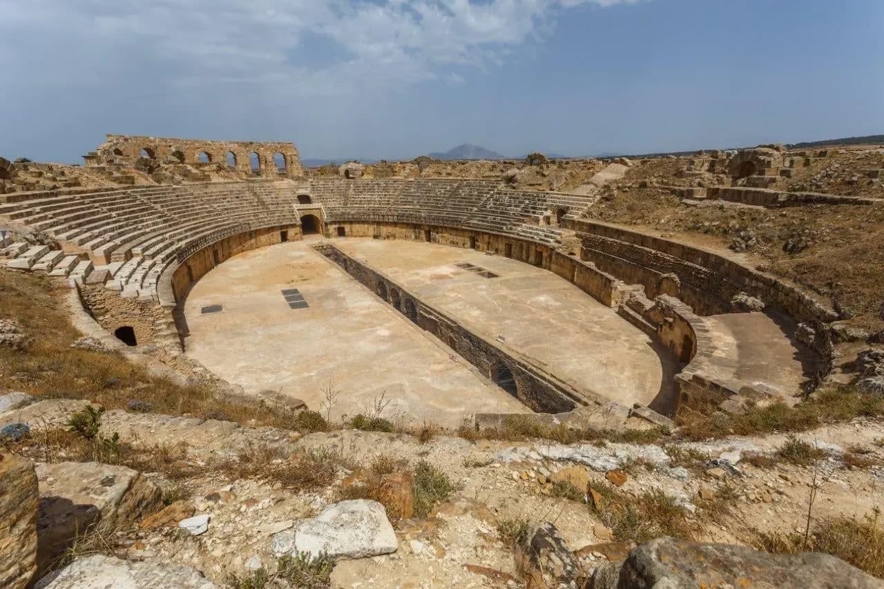 The oval arena and stone seating of a Roman amphitheatre