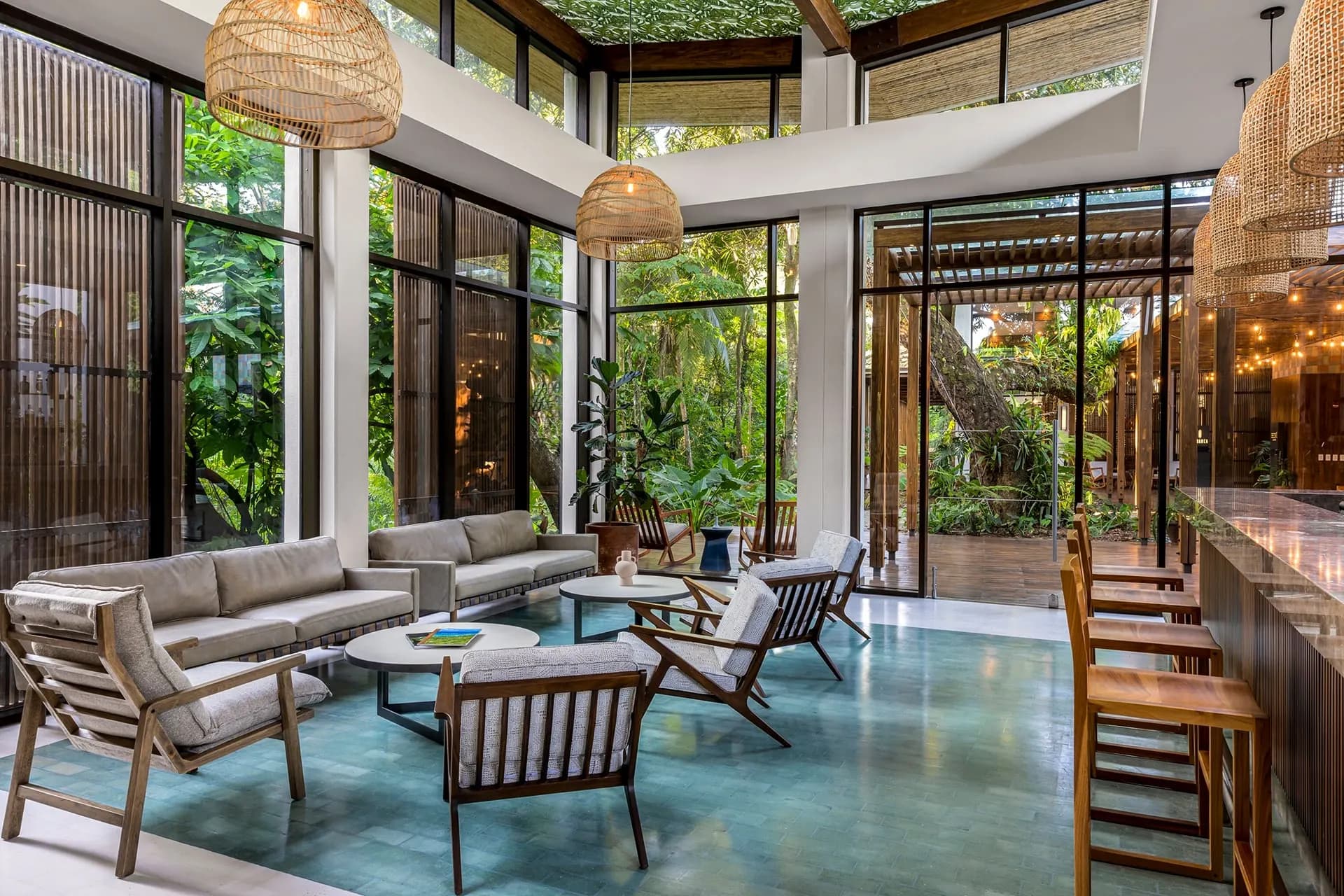 A bright lodge lounge with tall windows onto the forest