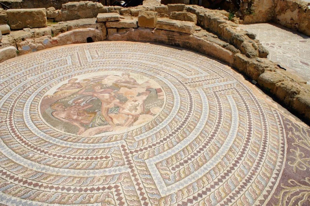 An ancient circular floor mosaic set in stone ruins