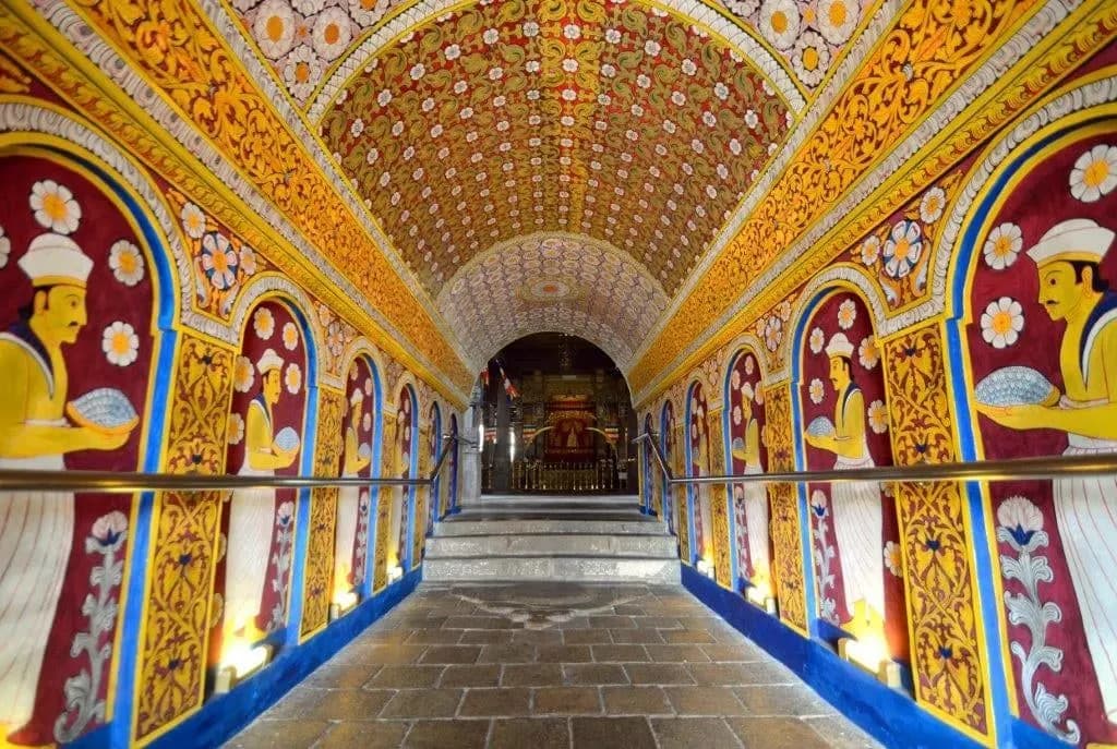 A vaulted temple corridor painted with bright murals and flowers